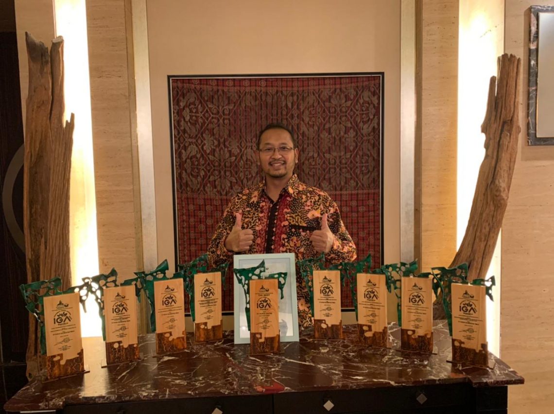 SVP Sekretaris Perusahaan PKT Teguh Ismartono berpose bersama plakat yang diterima Pupuk Kaltim sebagai The Best Indonesia Green Awards (IGA) 2022 dari La Tofi School of CSR. Foto: Humas Pupuk Kaltim