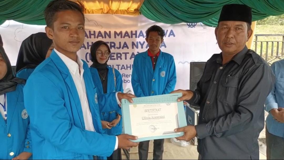 Penyerahan Piagam dari Kades TRP ke perwakilan mahasiswa Kukerta UIN Jambi. Foto: IST