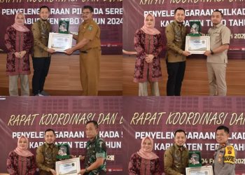 Ketua KPU Tebo mendampingi Anggota KPU Provinsi Jambi saat menyerahkan piagam penghargaan. FOTO: IST