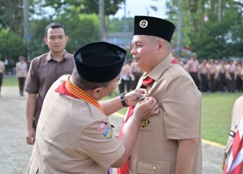 Kamabicab Kota Jambi, Dr Maulana Saat Menyematkan Pin Penghargaan Pancawarsa I kepada Ketua Kwarcab Kota Jambi, Kemas Faried Alfarelly. FOTO: ABI
