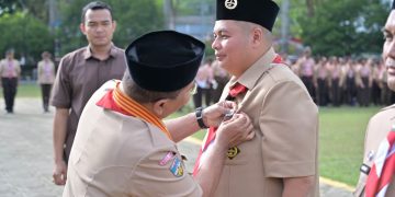 Kamabicab Kota Jambi, Dr Maulana Saat Menyematkan Pin Penghargaan Pancawarsa I kepada Ketua Kwarcab Kota Jambi, Kemas Faried Alfarelly. FOTO: ABI