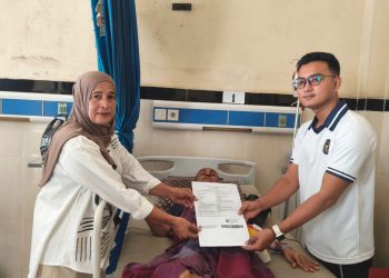 Kasubsi Bimkesmaswat Lapas Kelas IIA Jambi, Pandega Bayu Pratama saat menyerahkan surat bebas kepada perwakilan keluarga warga binaan. FOTO: OYI