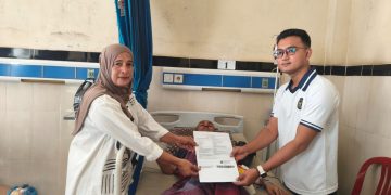 Kasubsi Bimkesmaswat Lapas Kelas IIA Jambi, Pandega Bayu Pratama saat menyerahkan surat bebas kepada perwakilan keluarga warga binaan. FOTO: OYI