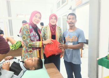 Ny Septi Irwan dan Ny Indah Askari saat menyerahkan santunan kepada perwakilan keluarga peserta sunatan massal. FOTO: OYI