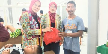 Ny Septi Irwan dan Ny Indah Askari saat menyerahkan santunan kepada perwakilan keluarga peserta sunatan massal. FOTO: OYI