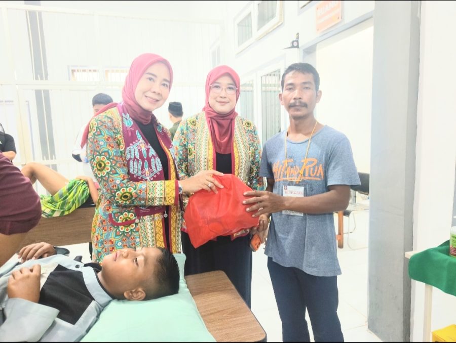 Ny Septi Irwan dan Ny Indah Askari saat menyerahkan santunan kepada perwakilan keluarga peserta sunatan massal. FOTO: OYI