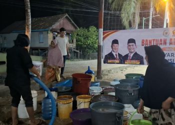 Relawan Rocky Candra saat menyalurkan air bersih kepada warga Tahtul Yaman Pelayangan. FOTO: IST