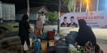 Relawan Rocky Candra saat menyalurkan air bersih kepada warga Tahtul Yaman Pelayangan. FOTO: IST