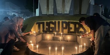 Pemasangan lilin di tugu pers oleh jurnalis. FOTO: IST