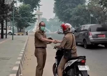 Kabid Bina Marga Dinas PUPR Provinsi Jambi, Iwan Rahmadi saat menyerahkan masker kepada pengguna jalan. FOTO: IST