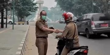 Kabid Bina Marga Dinas PUPR Provinsi Jambi, Iwan Rahmadi saat menyerahkan masker kepada pengguna jalan. FOTO: IST